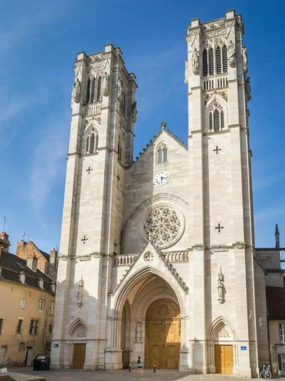 a church with a tall tower with a clock on it at La Demeure de Gaïa in Chalon-sur-Saône