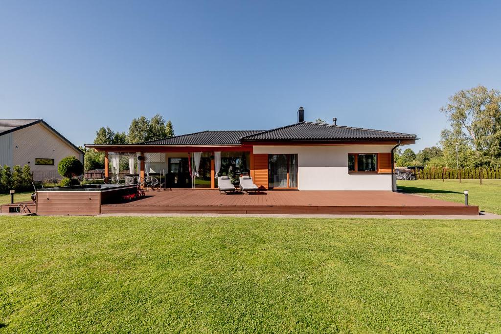 a house with a deck and a lawn at Valgekodu Pesa in Papsaare