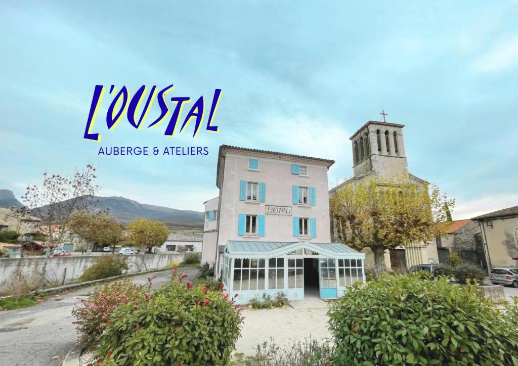 a sign for a hotel with a building at Oustal de Bourdeaux in Bourdeaux