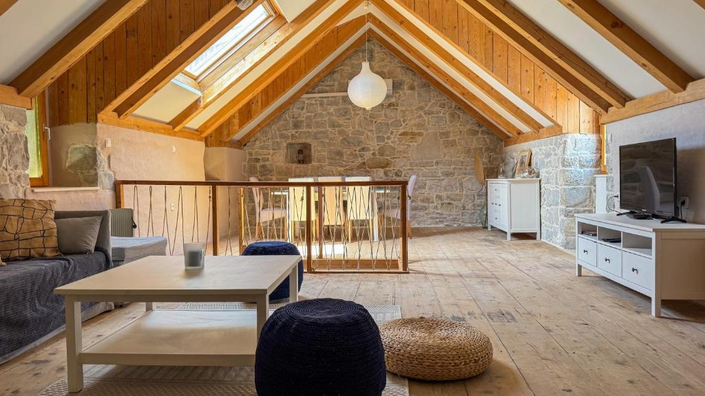 a living room with a couch and a table at Stone house Olsavinia close to the beach in Kaštela