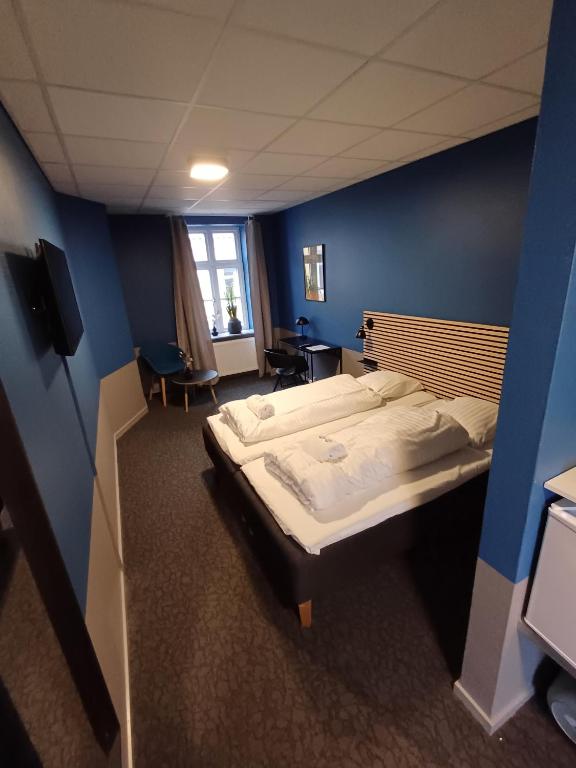 a bedroom with two beds and a blue wall at Double Room 1 with free parking in Saeby in Sæby