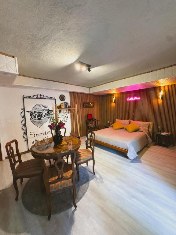 a bedroom with a bed and a table and chairs at Smith's house in Borgo San Dalmazzo