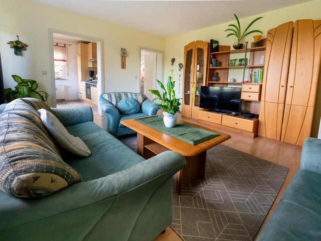 a living room with a couch and a table at EifelRuhe 3 in Hellenthal - ideal für Familien und Paare mit Hund - voll ausgestattete Küche und zwei Schlafzimmer in Hellenthal