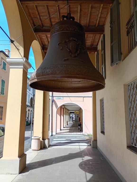 a large bell hanging from the side of a building at La finestra sulla campana in Brescello