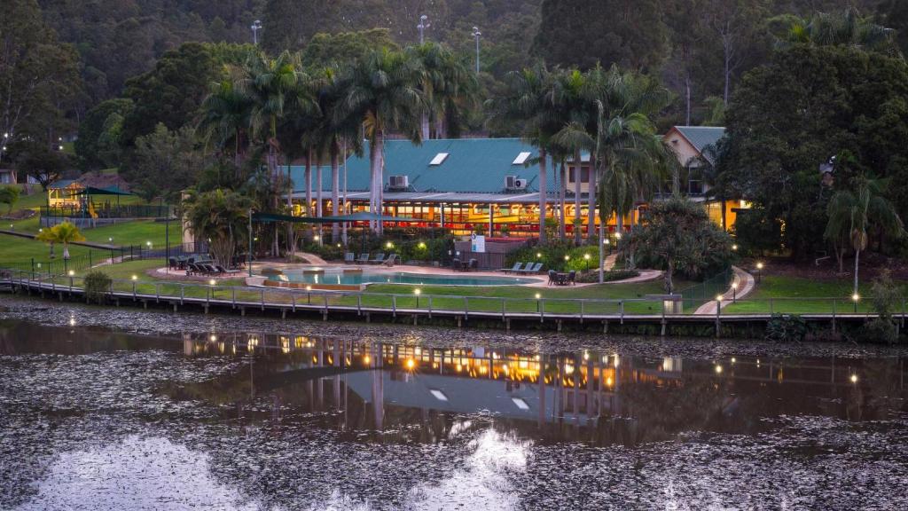 a building next to a body of water at Cedar Lake Country Resort in Nerang
