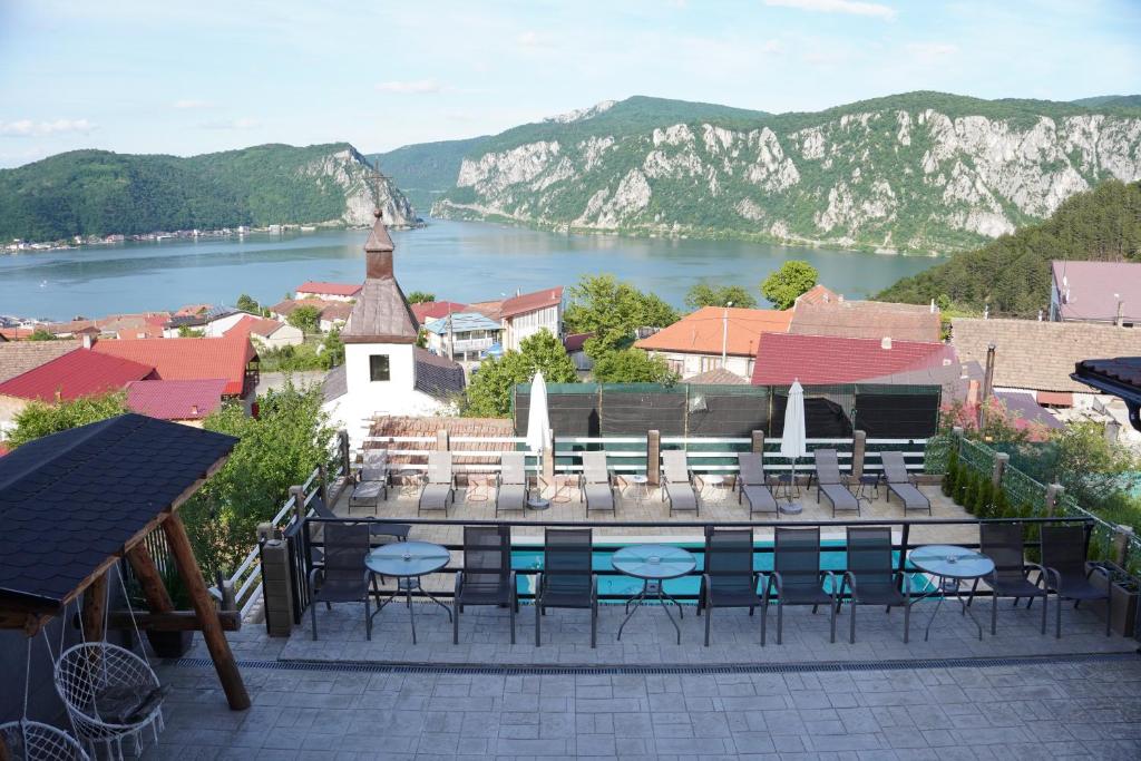 a group of chairs and tables on a patio overlooking a river at Casa Corina Dubova in Dubova