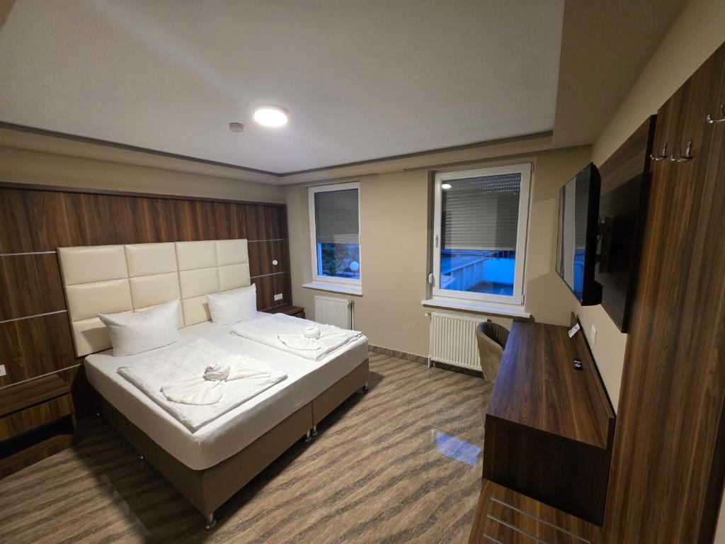 a bedroom with a bed and a flat screen tv at Hotel City Faber in Worms