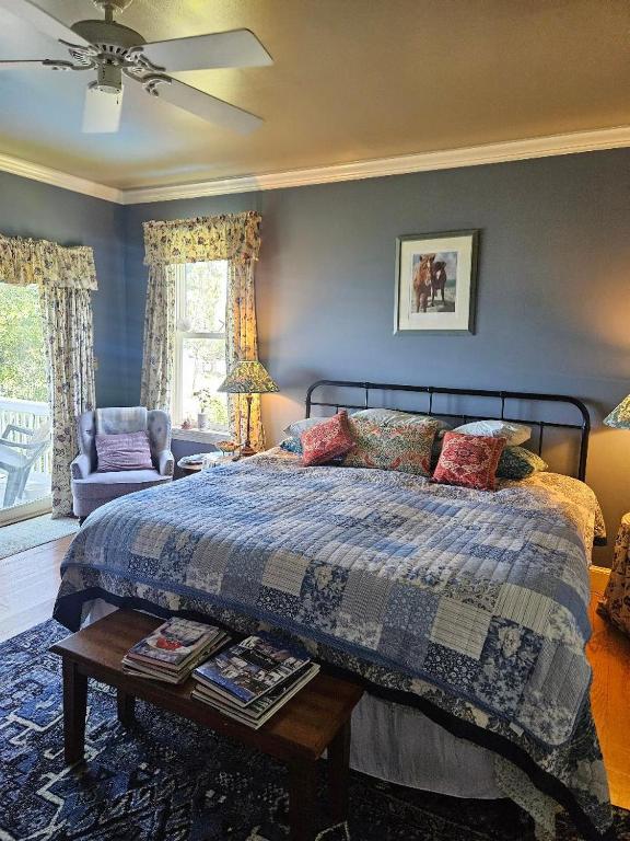 ein Schlafzimmer mit einem Bett und einem Tisch mit Büchern in der Unterkunft Gloucester House with Sea View in Gloucester