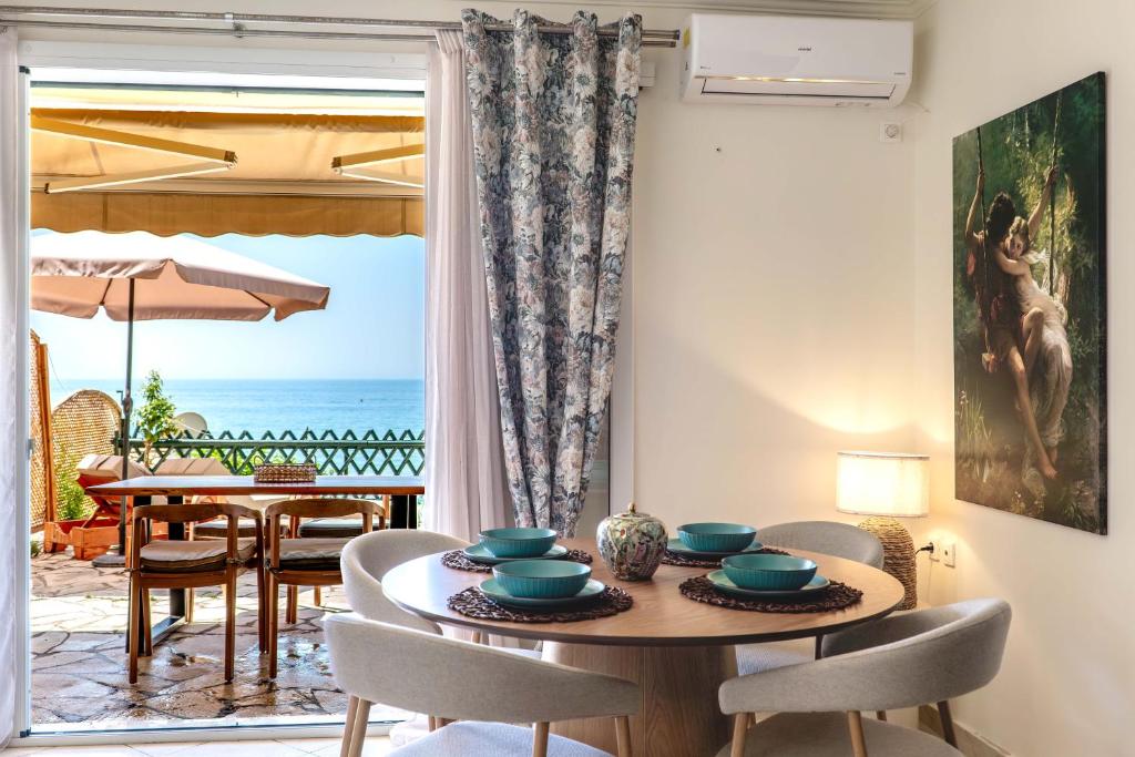 a dining room with a table and a view of the ocean at Corfu Dream Apartment Chrysion in Glyfada