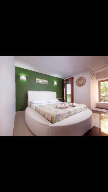 a large bed in a room with a green wall at DiemmeStudio in Salerno