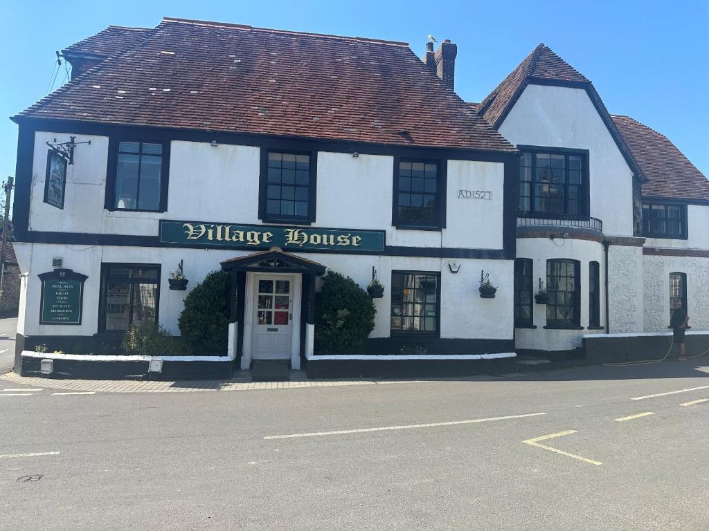 a white building on the corner of a street at The Village House in Findon