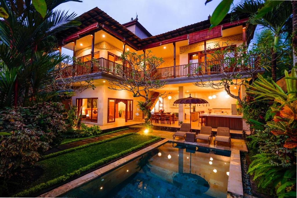 a house with a swimming pool in front of it at Villa Tenang in Ubud