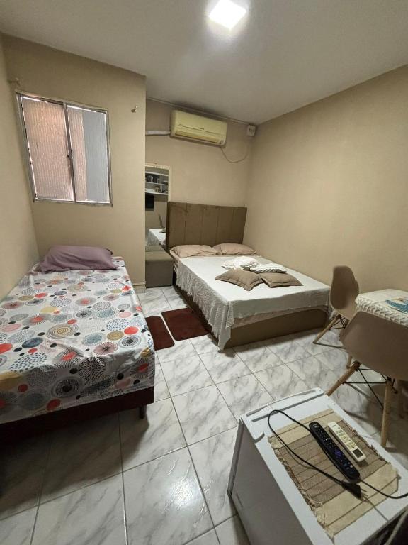 a room with two beds and a desk in it at SUITE banheiro privativo & 2 QUARTOS banheiro social PERTO DO GERALDÃO,ARENA PERNAMBUCO,UNIVERSO, UFPE,AEROPORTO-AFOGADOS- RECIFE in Recife