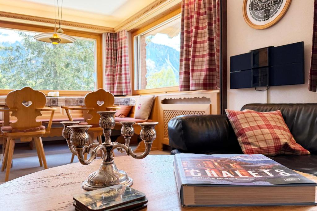 a living room with a table with a book at Panorama Apartment Gotschnablick 1-6 Pers in Klosters