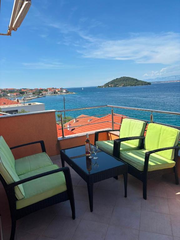 two chairs and a table on a balcony with the ocean at Lana&Ema in Kali