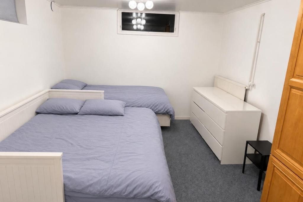 a bedroom with two beds and a dresser and a bedskirts at Boende i Vimmerby in Vimmerby