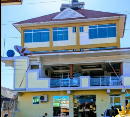 a large yellow building with a balcony on top of it at King Solomon Hotel in Nkunjila