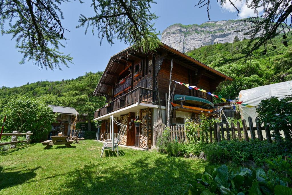 a wooden house with a mountain in the background at Chambre D'hôtes La Télécabine in La Balme-de-Thuy
