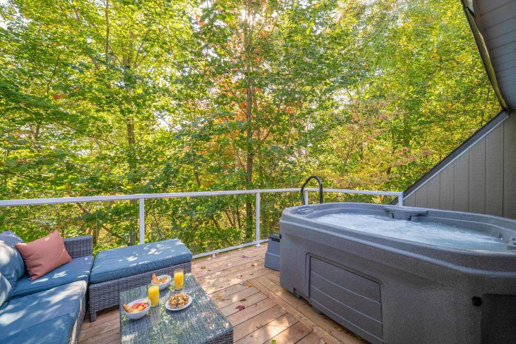 a large tub sitting on a deck with trees at Pool & Spa - Chalet Le Misco in Beaupré