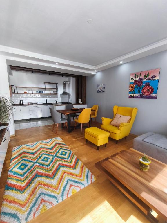 a living room with a couch and a table and yellow chairs at Ana VS Apartment in Ohrid