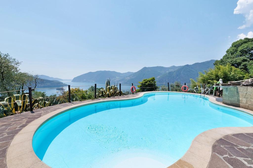 a large swimming pool with a view of the water at Agriturismo El Giardì in Marone