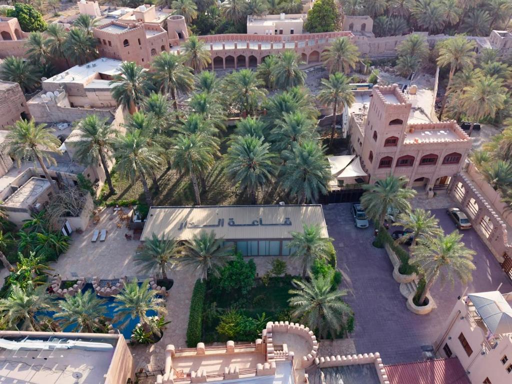 an aerial view of a resort with palm trees and buildings at Aldar Inn - نزل الدار in Nizwa