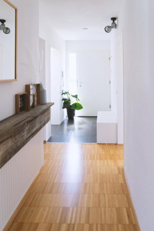 a hallway with white walls and a wooden floor at Apartment 39 in Giengen an der Brenz