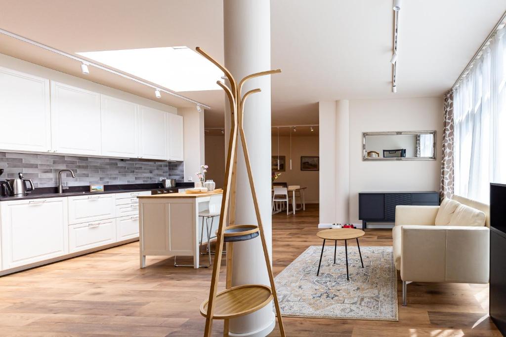 a kitchen and living room with white cabinets at Strandleben - Galerie Nummer 13 in Ahrenshoop