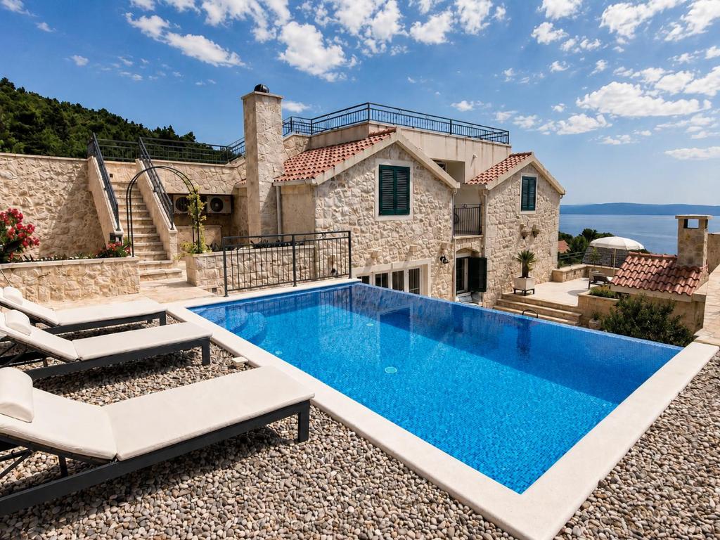 a villa with a swimming pool and a house at Steinhaus Villa Ane in Tučepi