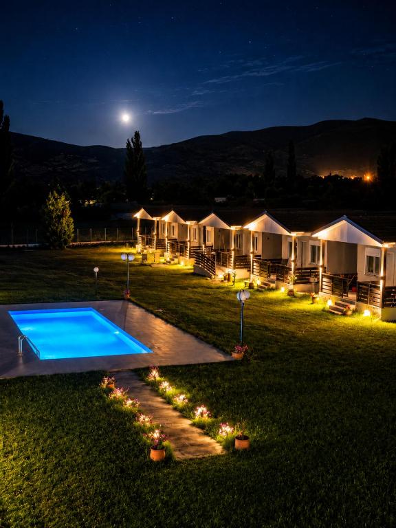 a row of luxury tents with a pool at night at Vigla summer house! in Paralia Sikias