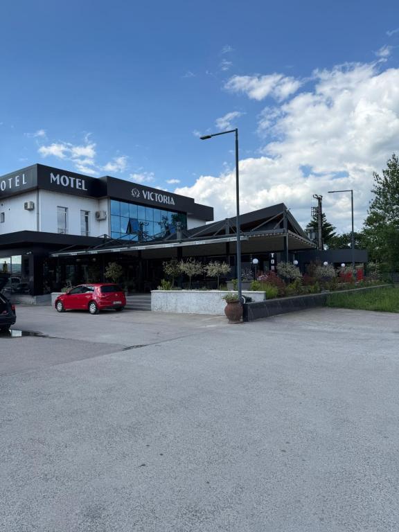 a building with a car parked in a parking lot at Motel Victoria in Zvornik