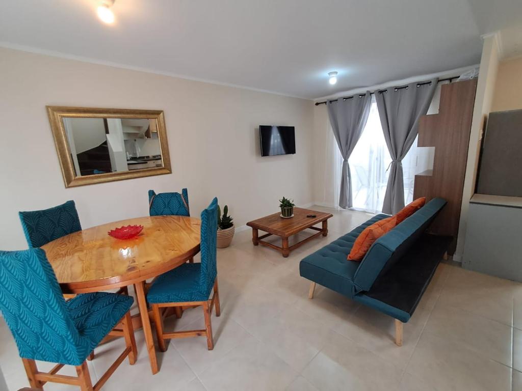 a dining room with a wooden table and blue chairs at Casa full equipada con tres camas y se puede habilitar una cuarta cama a solicitud in Antofagasta