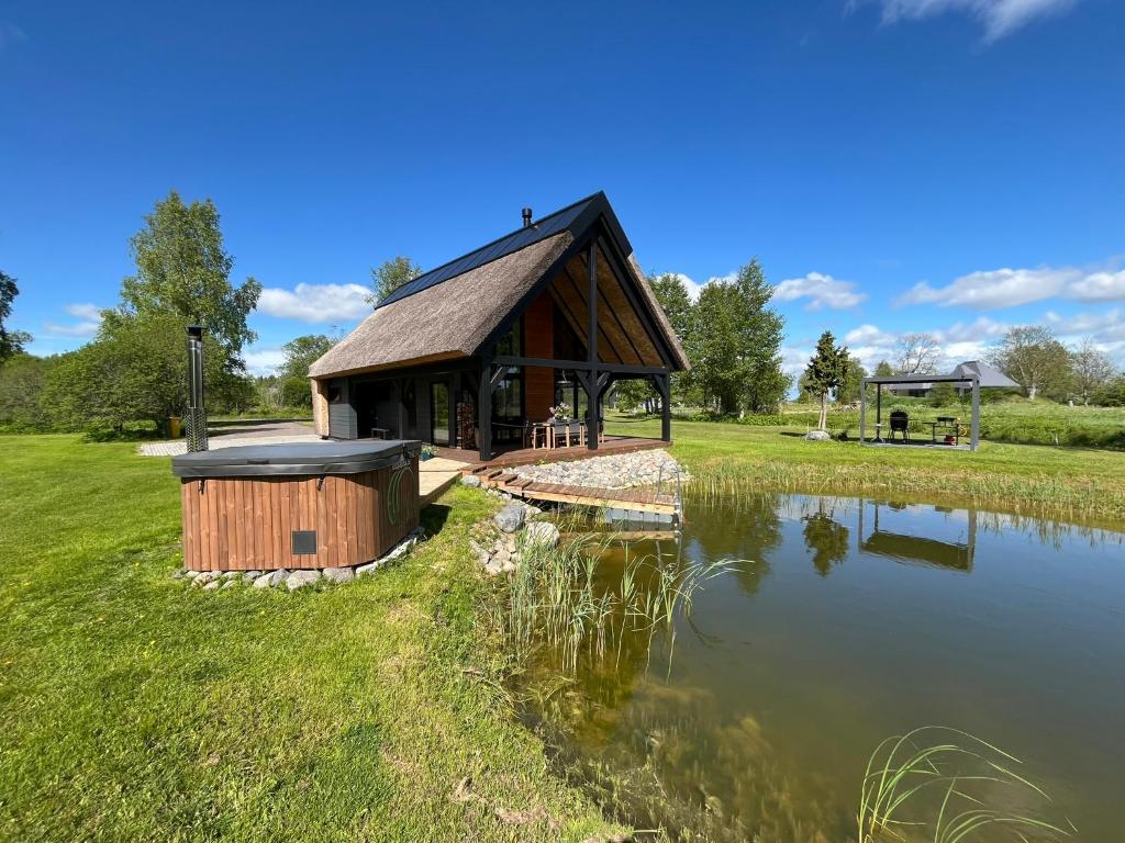a large wooden building next to a body of water at Mihkliranna Puhkemaja in Marksa