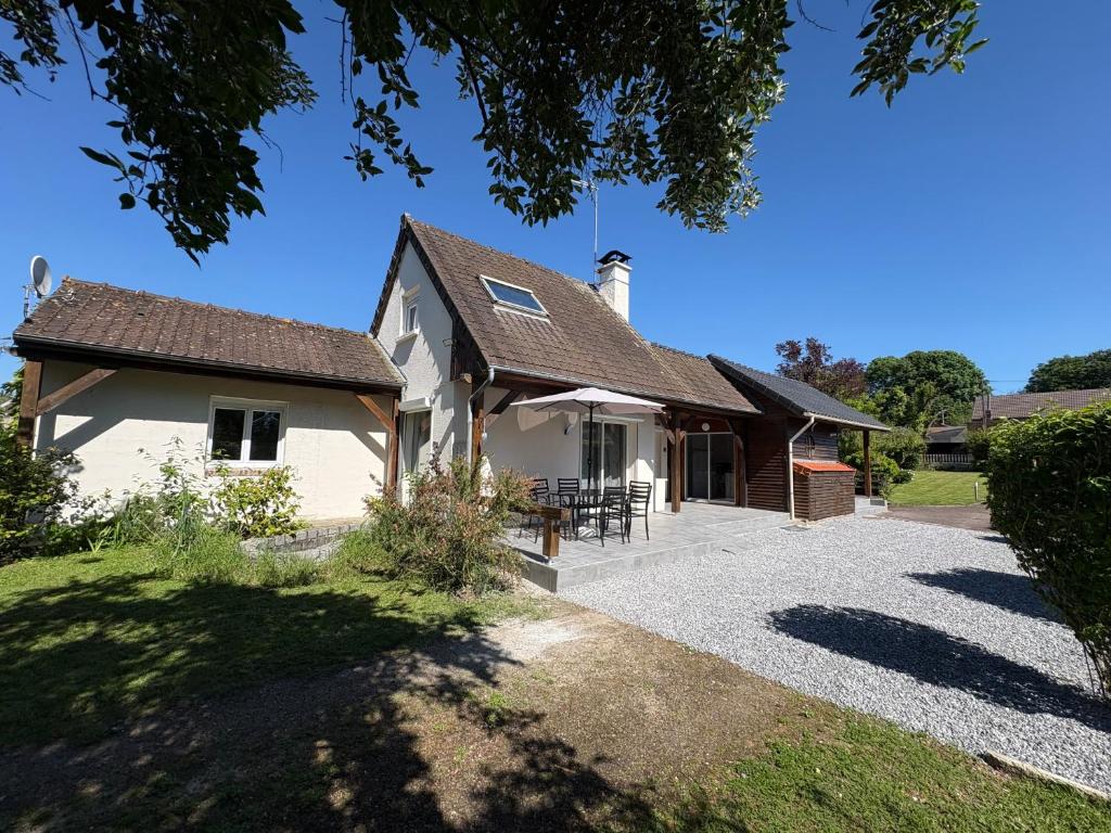 a white house with a patio in front of it at Le chalet de l Escaut in Bantouzelle