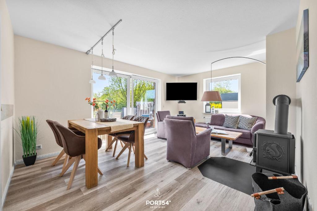a living room with a dining table and a fireplace at Ferienwohnung Luv Dagebüll in Dagebüll