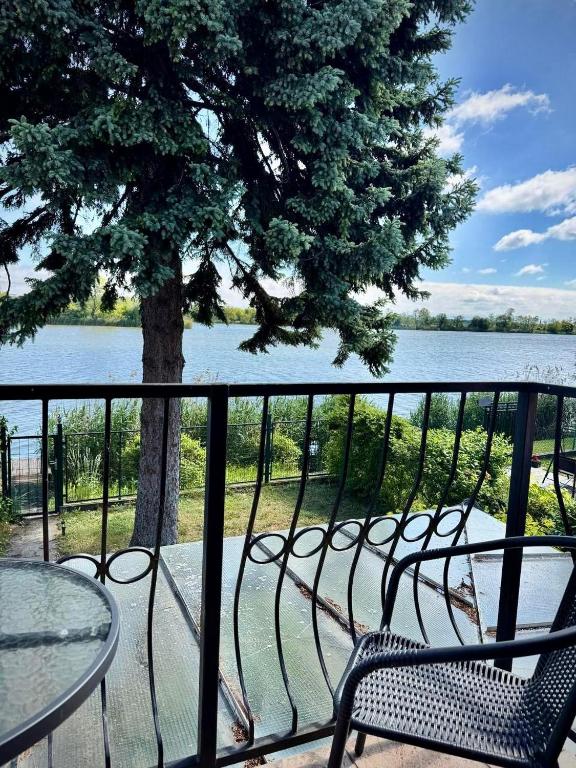 a balcony with chairs and a table and a tree at Apacs Villa in Ráckeve