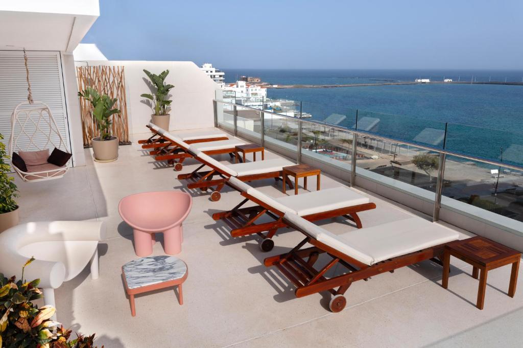 a row of tables and chairs on a balcony with the ocean at Plus Fariones Habitat in Arrecife