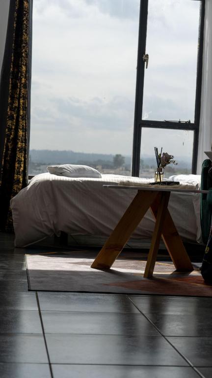 a bed with a wooden table in a room with a window at Stylish 10th Floor Studio with great Views ,Fast Wi-Fi and Secure in Nairobi