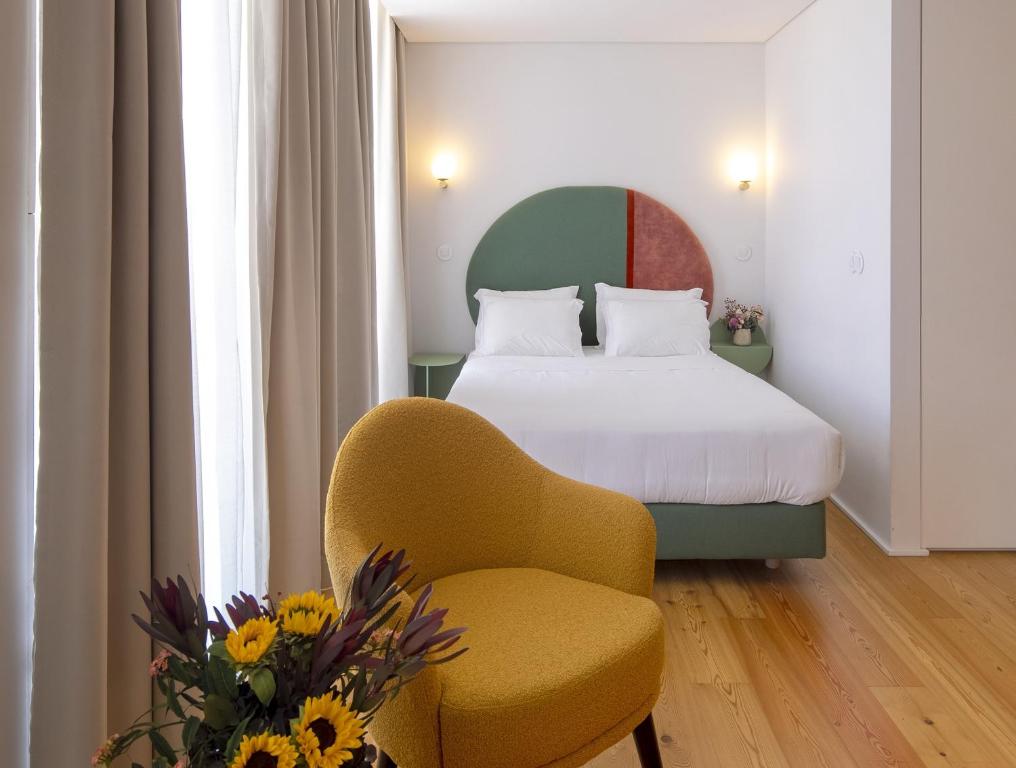 a hotel room with a bed and a chair at LSA Estrela by Numa in Lisbon