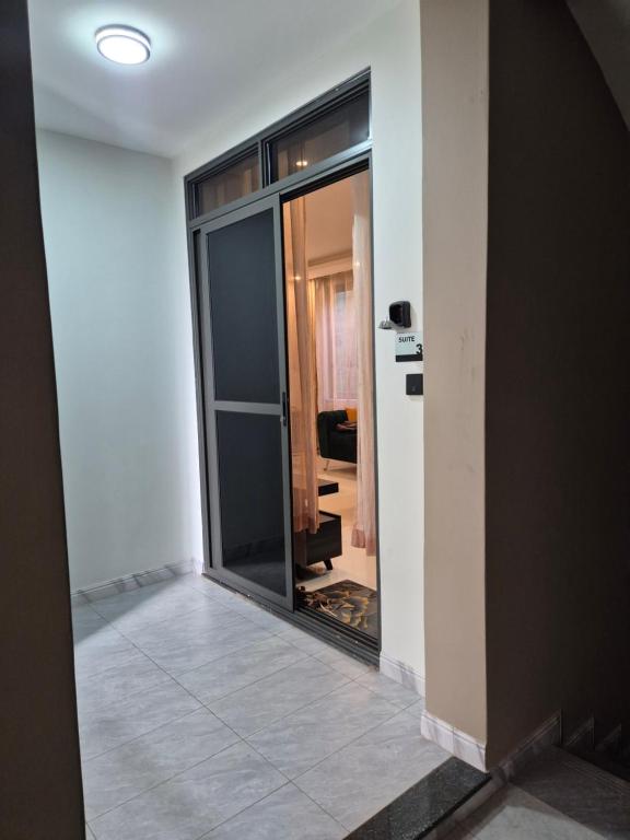 an empty room with a glass door and a mirror at CozyStay Homes in Kampala