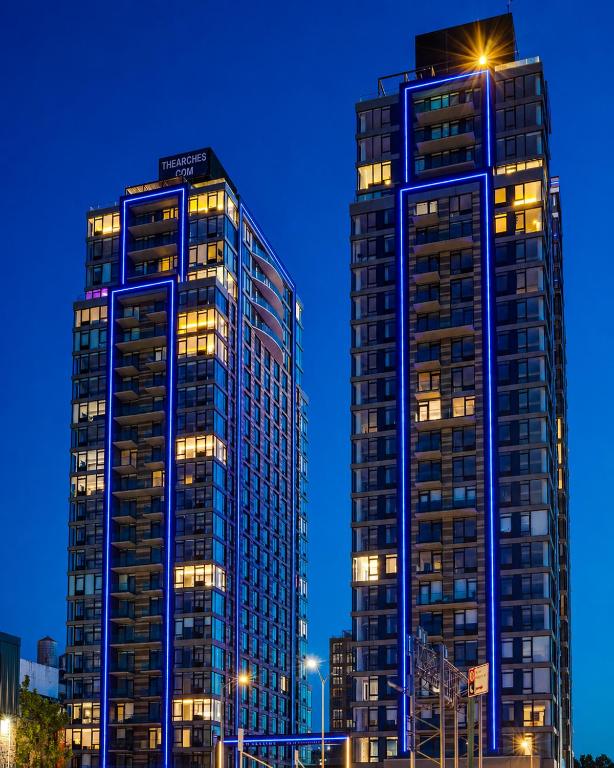 two tall buildings in a city at night at Global Luxury Suites at The Arches in Bronx