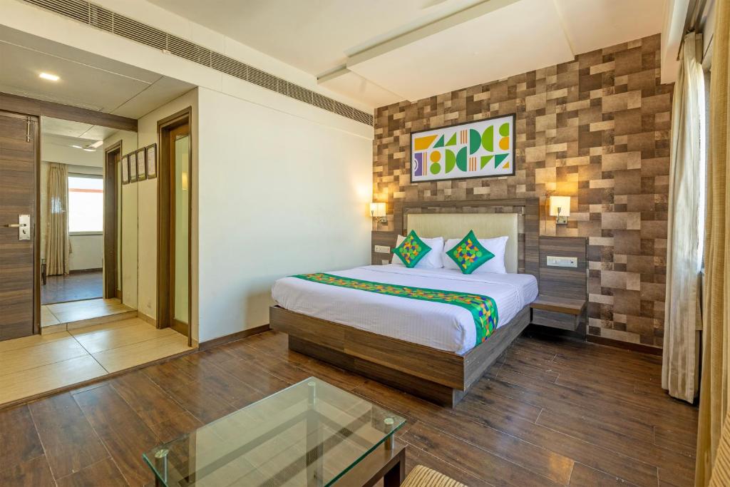 a bedroom with a bed and a glass table at Treebo Aaram Orchard in Ahmedabad