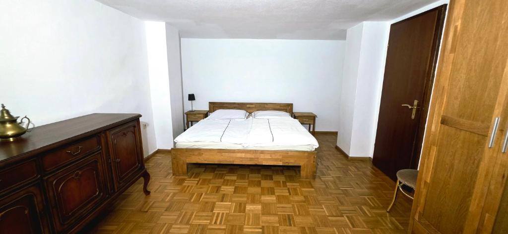 a small bedroom with a bed and a wooden dresser at Ferienhaus am Doctorberg in Bernkastel-Kues