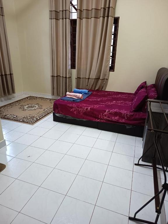 a bedroom with a bed with purple sheets and curtains at Jiddah Homestay in Tumpat