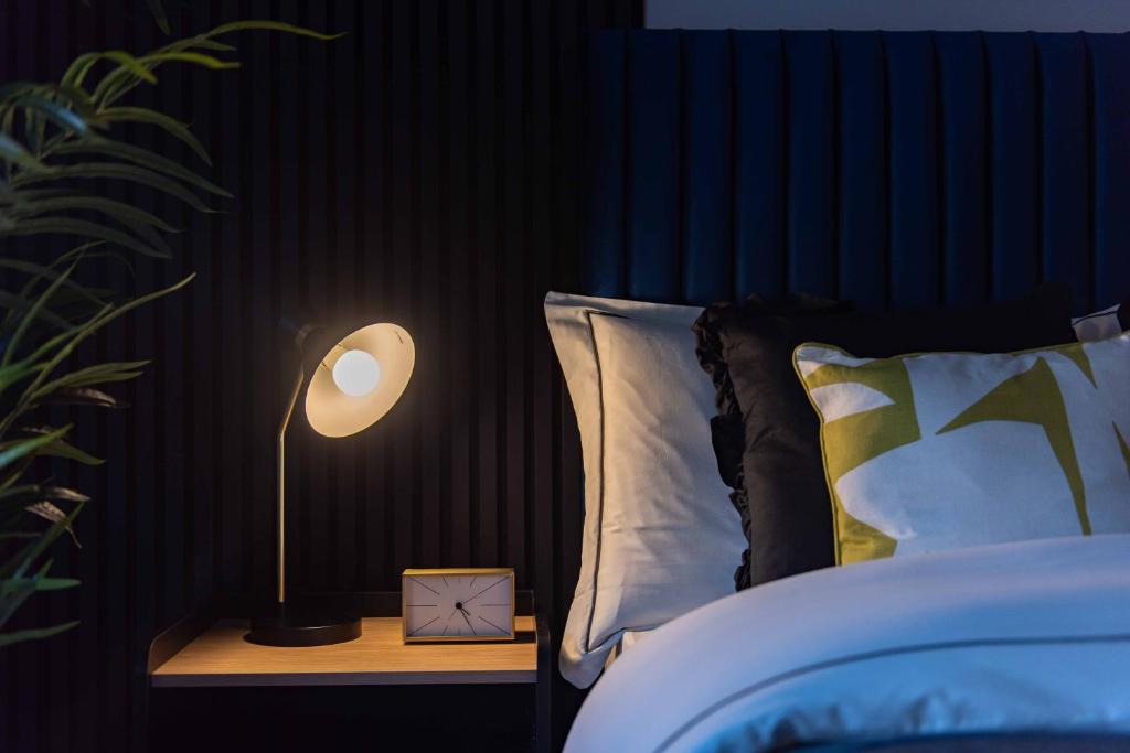 a bedroom with a bed with a lamp on a night stand at Central Sheffield Stay, Work Trips, Contractors & City Breaks in Sheffield