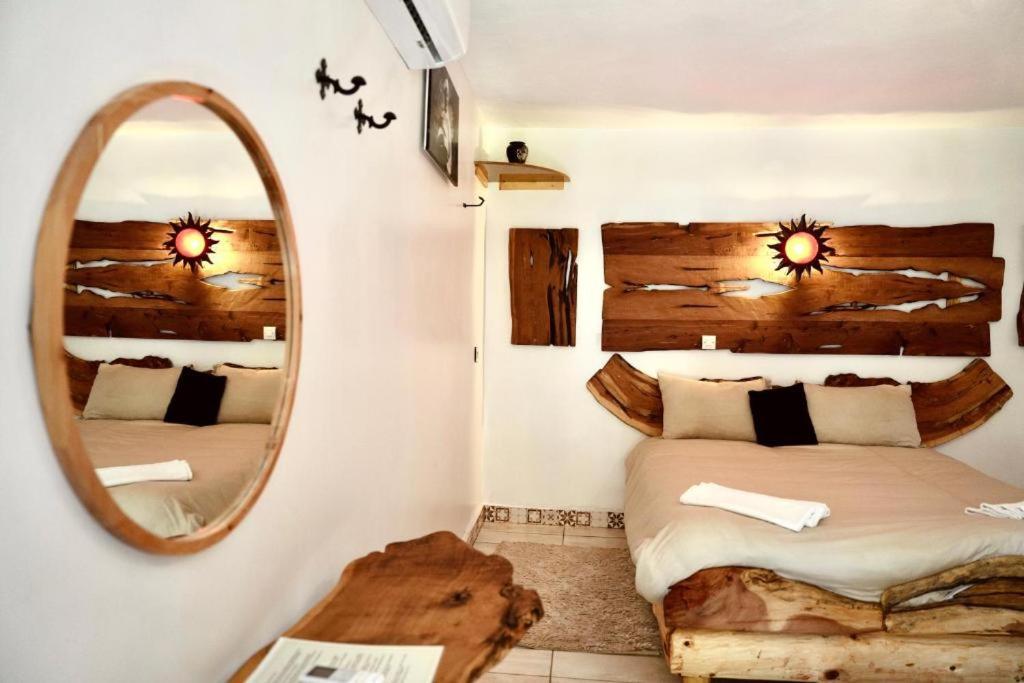 a bedroom with two beds and a mirror at Dar l'eau Vive in Bine el Ouidane