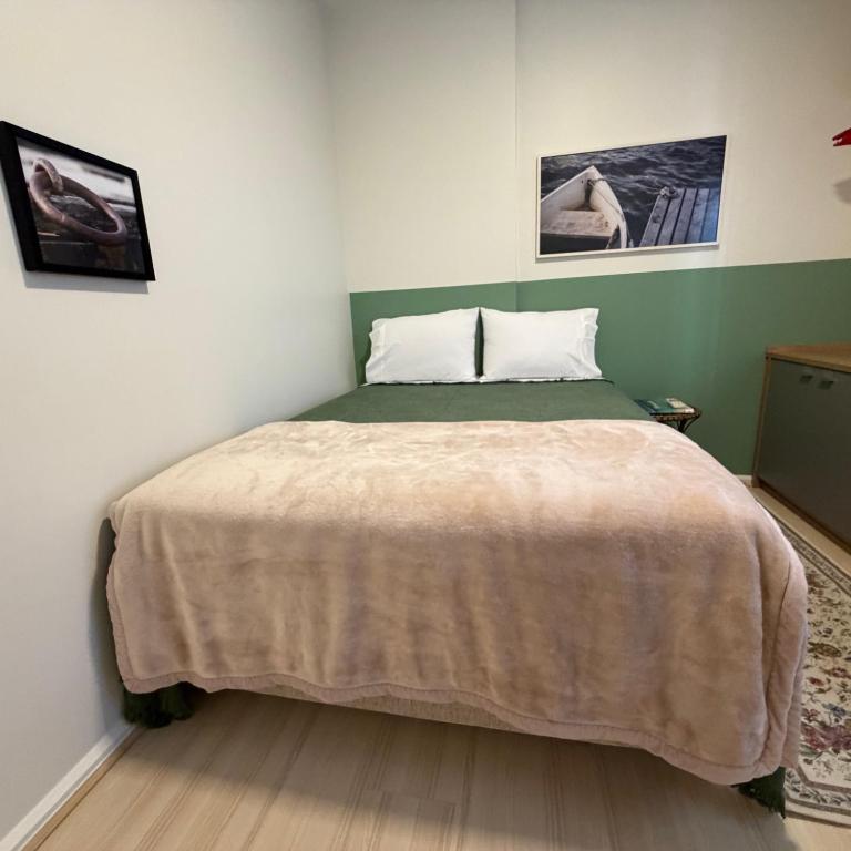 a bedroom with a bed with a blanket on it at QUARTO INTEIRO com banheiro exclusivo Coração de Florianópolis in Florianópolis