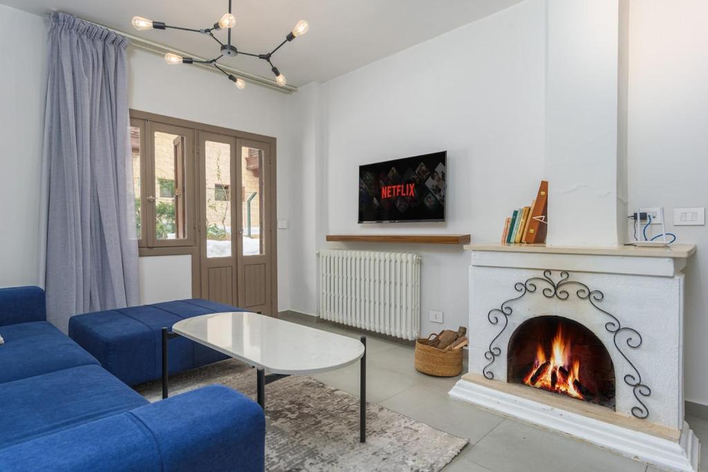 a living room with a blue couch and a fireplace at Maison Montagne Mzaar in Kfardebian