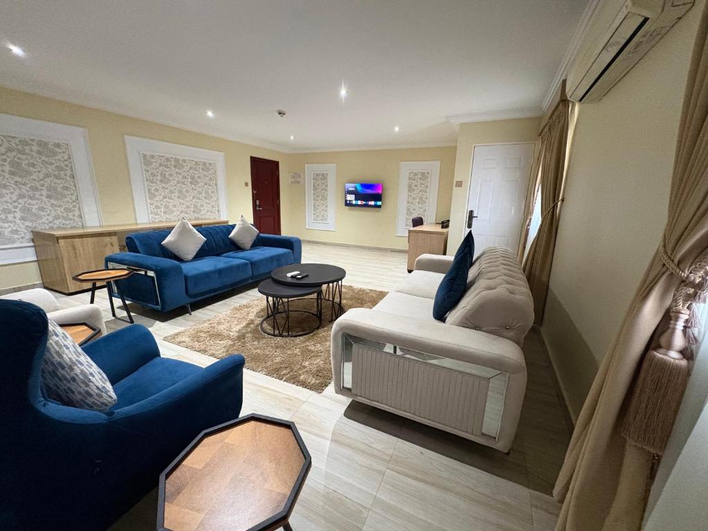 a living room with blue couches and blue chairs at Visa Karena Hotels in Port Harcourt