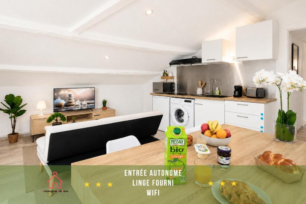 a kitchen and a living room with a table at " L'Oratoire Mansardé " Linge fourni - Wifi - TV in Lagardelle-sur-Lèze